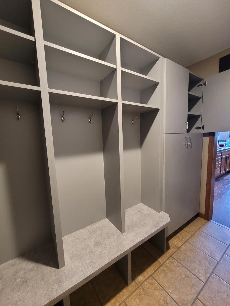 Storage nooks with hooks for clothing and enclosed cabinets on the right side