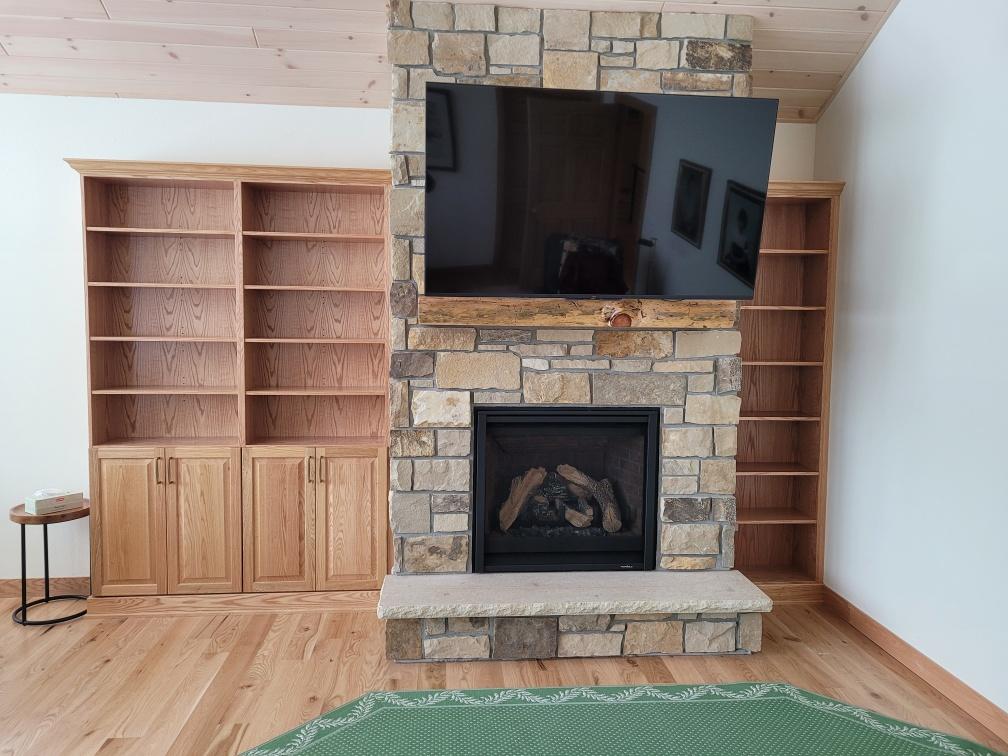 Custom bookshelves & cabinets on each side of a TV/fireplace